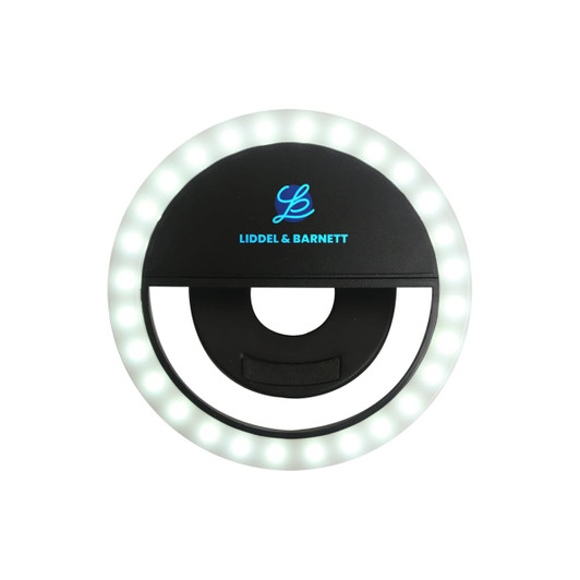 A round, black selfie ring light with white LEDs around the edge and a central opening for attaching to devices.