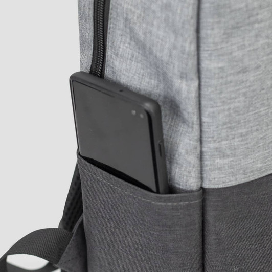 A grey backpack with a black section and a phone stored in a side pocket. It features a logo.