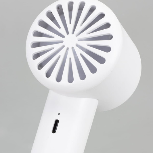 A white personal cooling fan featuring a circular grill design, with a charging port at the base.