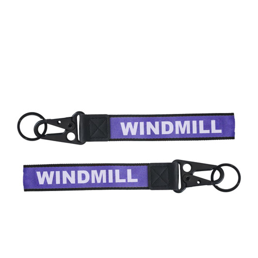 A purple Jacquard keyring featuring a black clip and two keyring loops. It has a branding element.