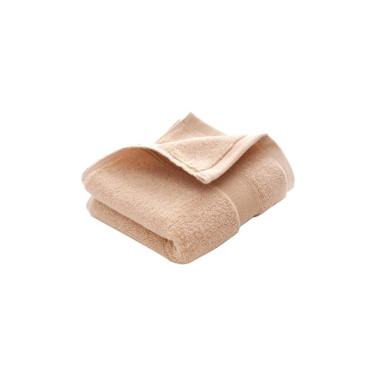 A folded beige cotton hand towel with a textured surface, featuring a logo on the side.