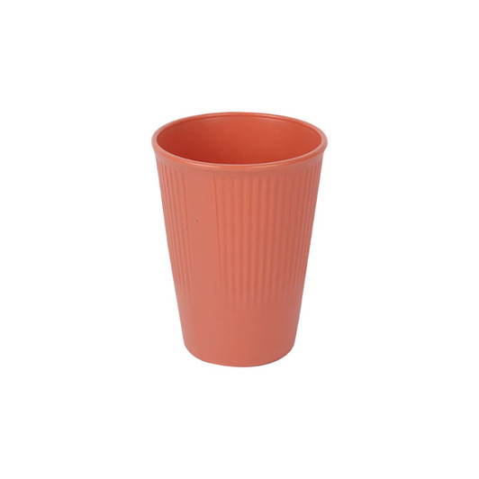 A wheat straw toothbrush cup in a coral colour with a ribbed texture and a logo.