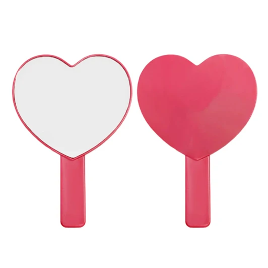 A heart-shaped handheld mirror with a pink handle, featuring a smooth reflective surface.