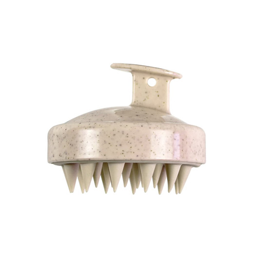 A hair scalp massager in cream colour with a smooth top and pointed bristles for massage. Features a loop for easy handling.