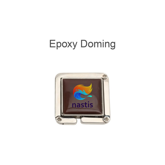 A square, foldable desk hook with a shiny silver finish and a coloured epoxy doming featuring a logo.