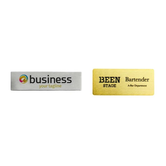 Two metal name badges, one silver and one gold, featuring different designs and a logo on each.