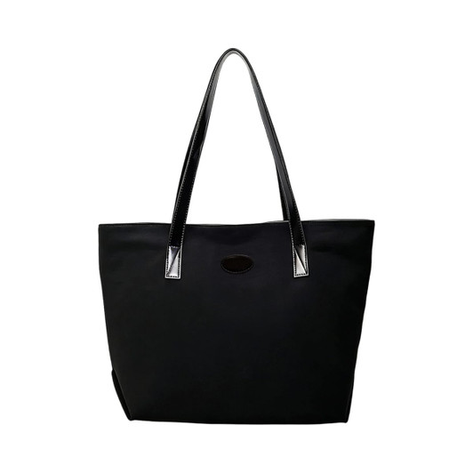 A black suede leather tote bag with long black handles and a simple design, featuring a logo.