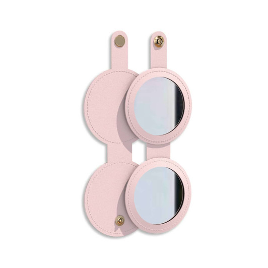 A round folding pocket mirror in a soft pink casing, featuring a logo on the front and two mirrored surfaces.