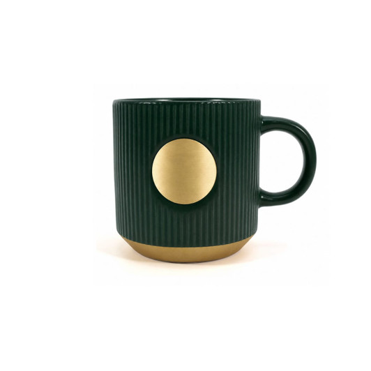 A ceramic coffee mug in dark green with a bronze circular accent and ribbed texture, featuring a logo.