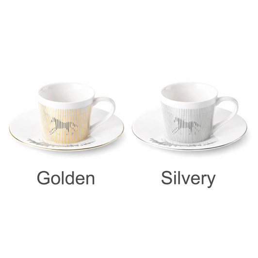 A coffee mug set featuring two dynamic ceramic mugs in golden and silvery finishes, each with a matching saucer and branding.