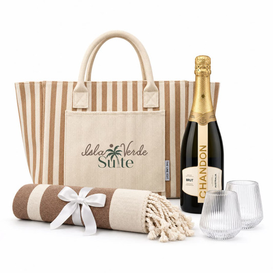 A striped tote bag, a champagne bottle, two glasses, and a blanket with a bow, all in neutral tones.