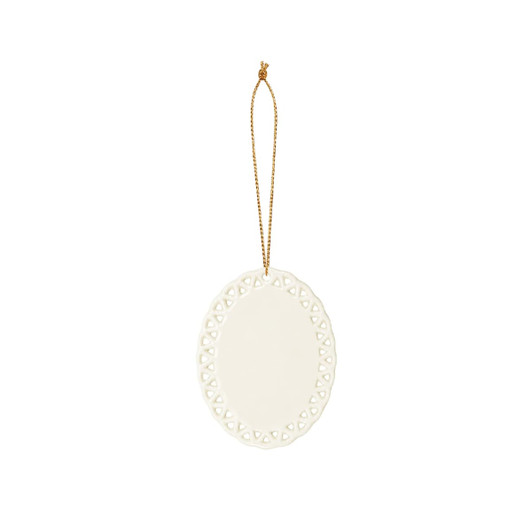 A ceramic ornament in white with a decorative lace-like edge and a gold hanging string.