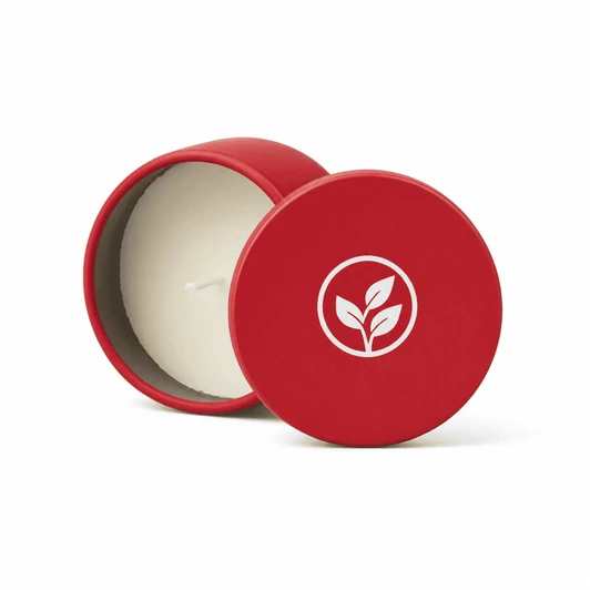 A red mini tin candle with a white wick and a lid featuring a leaf logo.