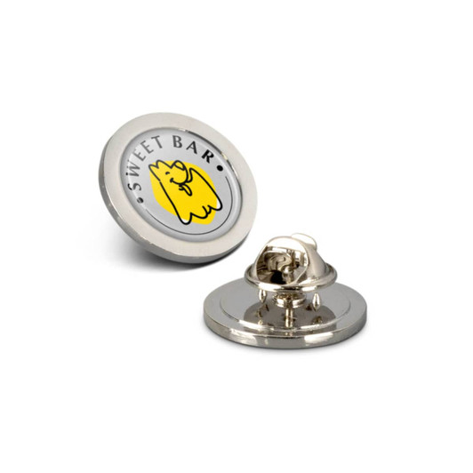A round silver lapel pin with a yellow character design and a branding logo on a white background.