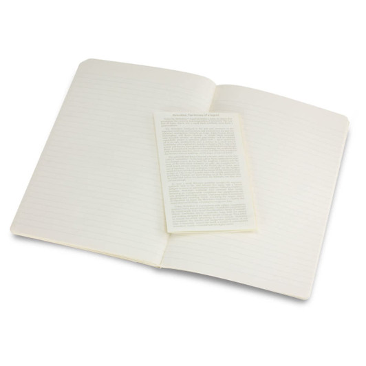 A large Moleskine Volant journal with blank pages, opened to display an inner leaflet. The cover is a neutral colour.
