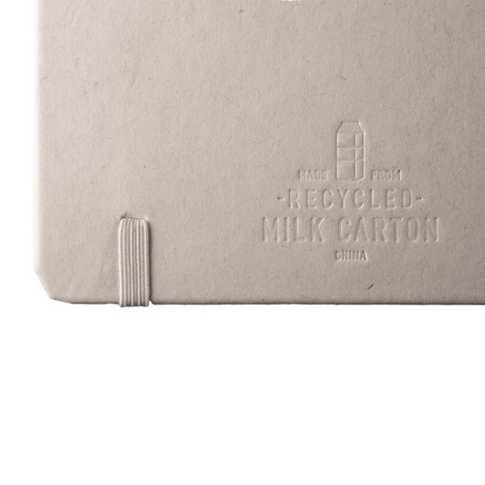 A recycled milk carton notebook with a textured grey cover and elastic band closure. It features branding on the back.