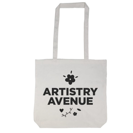 A tote bag with a long handle featuring the text "ARTISTRY AVENUE" and decorative floral elements.