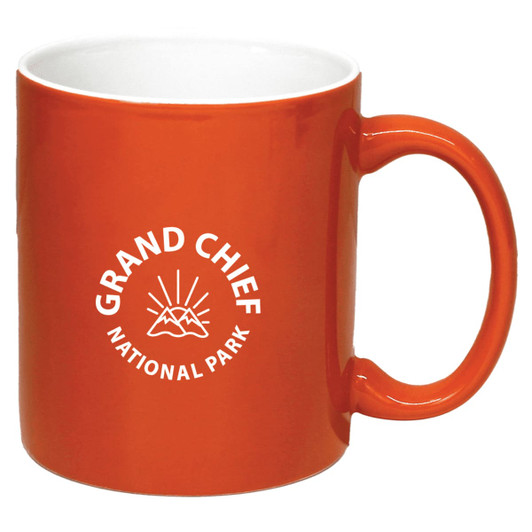 An orange coffee mug with a white interior and a logo featuring mountains and rays.