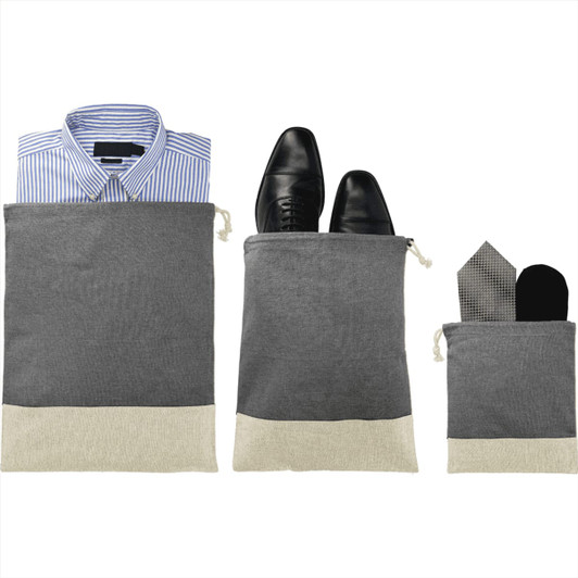 Three grey and beige travel pouches, each containing a shirt, shoes, and accessories like a tie and socks.