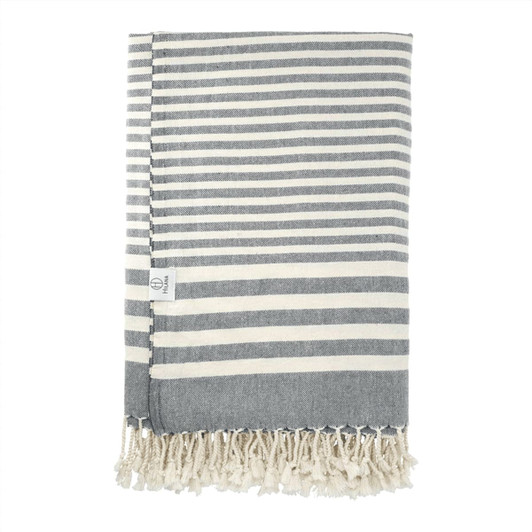 A striped throw blanket in grey and cream, featuring a fringed edge and a small logo.