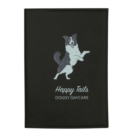 A black refillable journal with a design featuring a jumping dog and text for "Happy Tails Doggy Daycare."