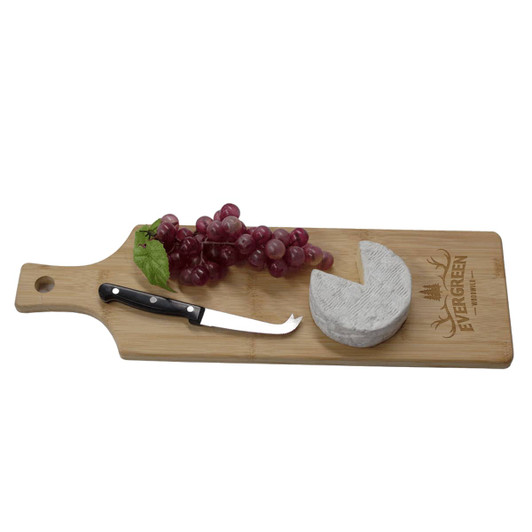 A bamboo serving board with a cheese round, grapes, and a cheese knife, featuring a logo on the surface.