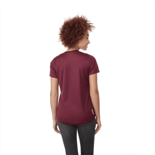A woman wearing a short sleeve tech tee in burgundy, viewed from the back, featuring a logo.