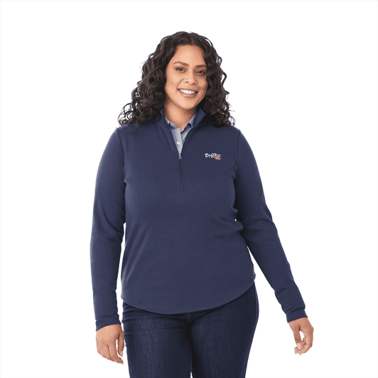 A navy quarter zip jacket for women featuring a logo, paired with a collared shirt and denim.