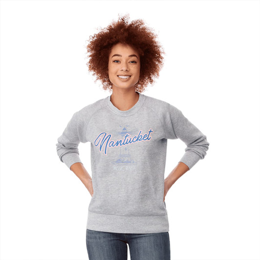 A woman with curly hair wears a grey fleece crew jumper with a design featuring the word "Nantucket."