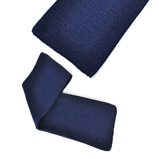 Acrylic scarf in dark navy blue, featuring a smooth texture and a folded design. Includes a logo.