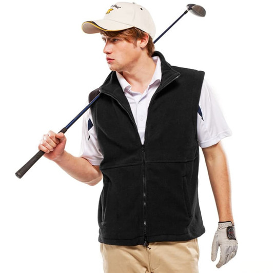 A young man wearing a black polar fleece vest, holding a golf club over his shoulder, dressed in a white shirt and cap.