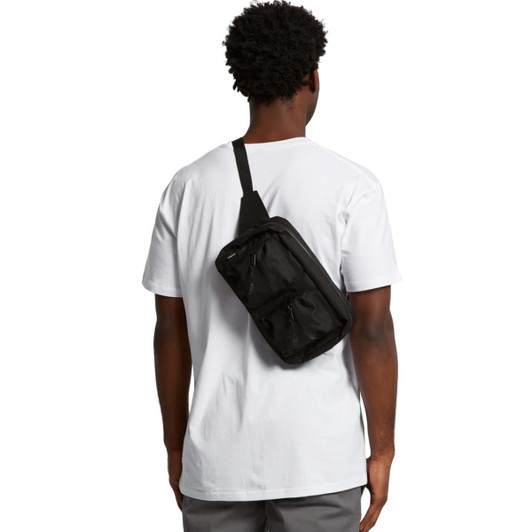 A black recycled double waist bag worn across the back of a person in a white T-shirt. The bag features a logo.