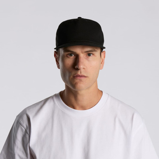 A black cap featuring a structured design, worn by a model in a white t-shirt, with a logo on the front.