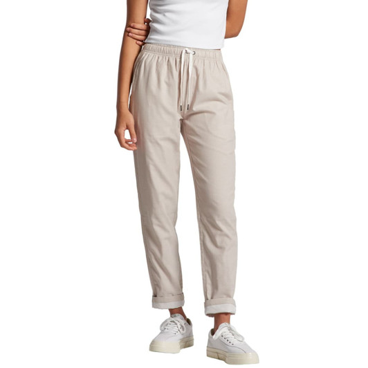 A pair of light beige pants with an elasticised waistband and rolled cuffs, featuring a brand logo.