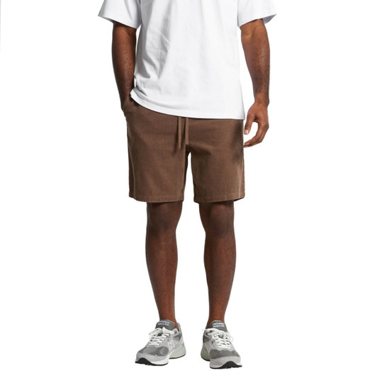 Cord shorts in a rich brown colour, featuring an elastic waistband and side pockets, paired with athletic shoes.