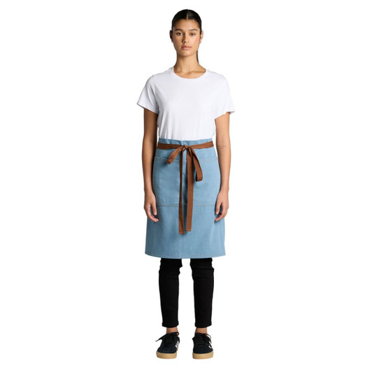 A denim half apron in light blue with a brown waist tie, displayed on a model wearing a white T-shirt and black pants.