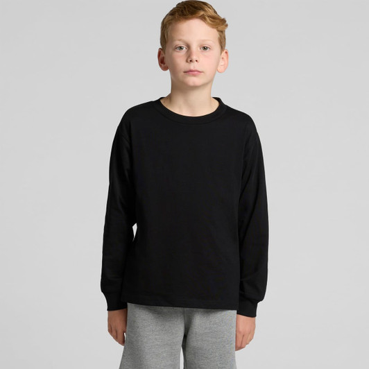 A black long-sleeve t-shirt for youth modelled by a child, paired with grey pants. The shirt features a logo.