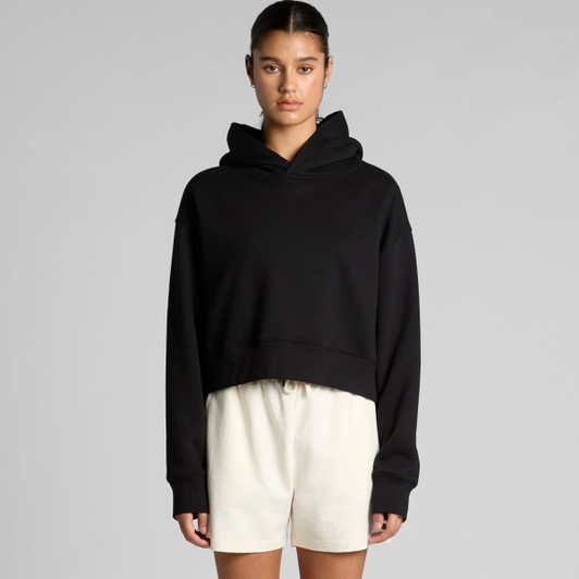 A black cropped hoodie with a hood and long sleeves, styled casually with light-coloured shorts.