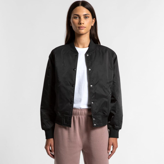 A black bomber jacket featuring a front snap closure, worn over a white shirt and light-coloured pants.