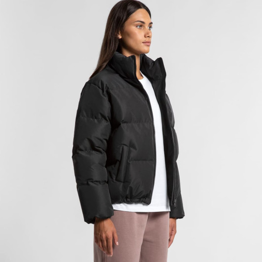 A black puffer jacket with a high collar and side pockets, worn by a model standing against a neutral background.