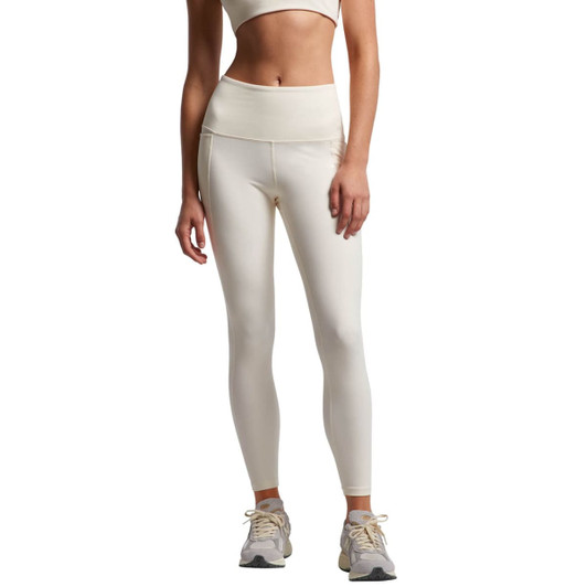 A pair of cream-coloured active leggings featuring a high waistband, modelled with a matching crop top and trainers.