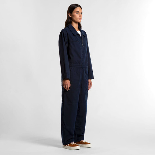 A side view of navy blue canvas coveralls with a zippered front and long sleeves, featuring a logo.