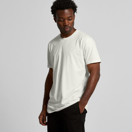 A light green organic T-shirt displayed on a model against a neutral background. The shirt features a subtle branding element.