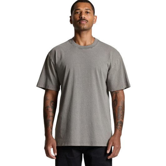 A heavy faded tee in a grey colour, featuring a loose fit and short sleeves, displayed on a model with tattoos.