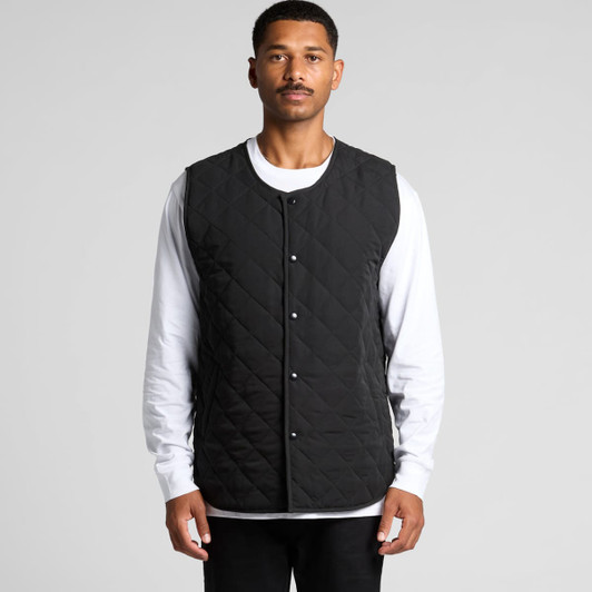 A quilted vest in black, featuring a button-up front and a simple design, worn over a white long-sleeve shirt.