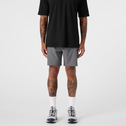 A pair of grey sports shorts paired with a black top, worn by a person with visible tattoos.