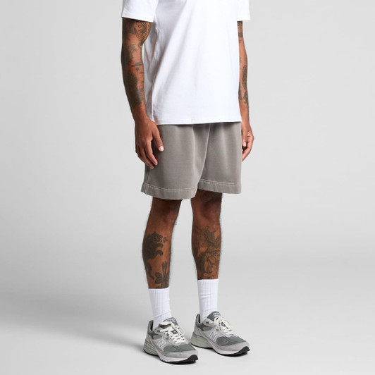 Faded grey track shorts with an elastic waistband, modelled by a person wearing a white T-shirt and trainers.
