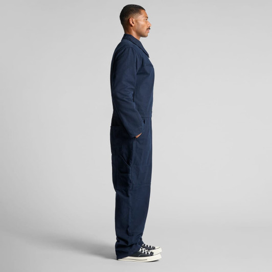 A navy canvas coverall featuring a zip front and side pockets, presented in a side view.