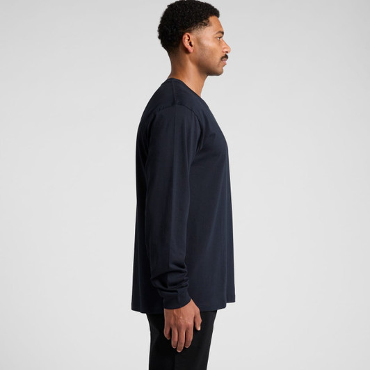 A long-sleeve navy T-shirt worn by a model, featuring a simple design and a logo on the front.