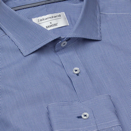 A blue and white check shirt with a button-up collar and branded tag. Features small buttons on the front.